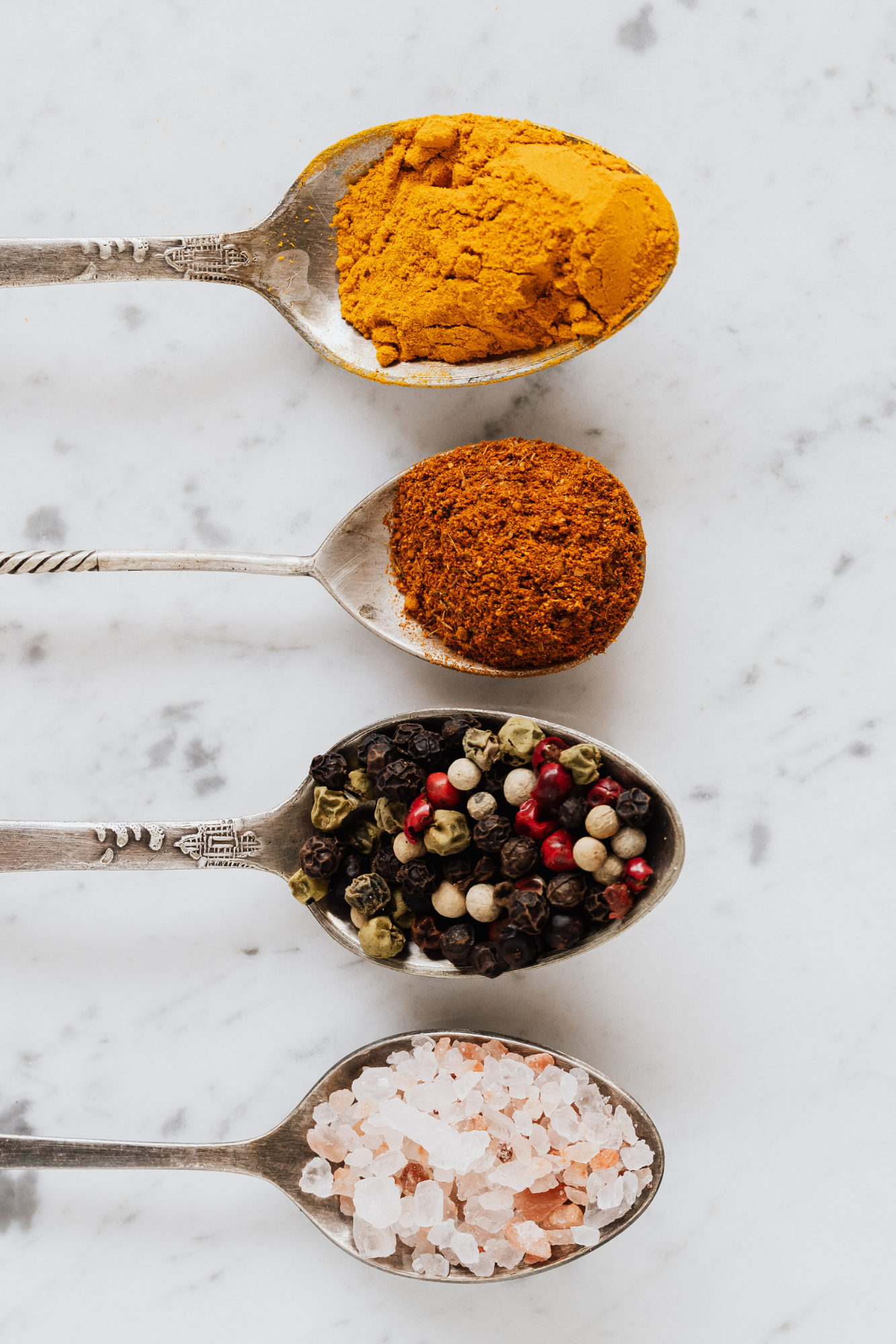 cuillères remplies d'épices: curcuma, cumin, poivres 5 baies, sel de l'Himalaya